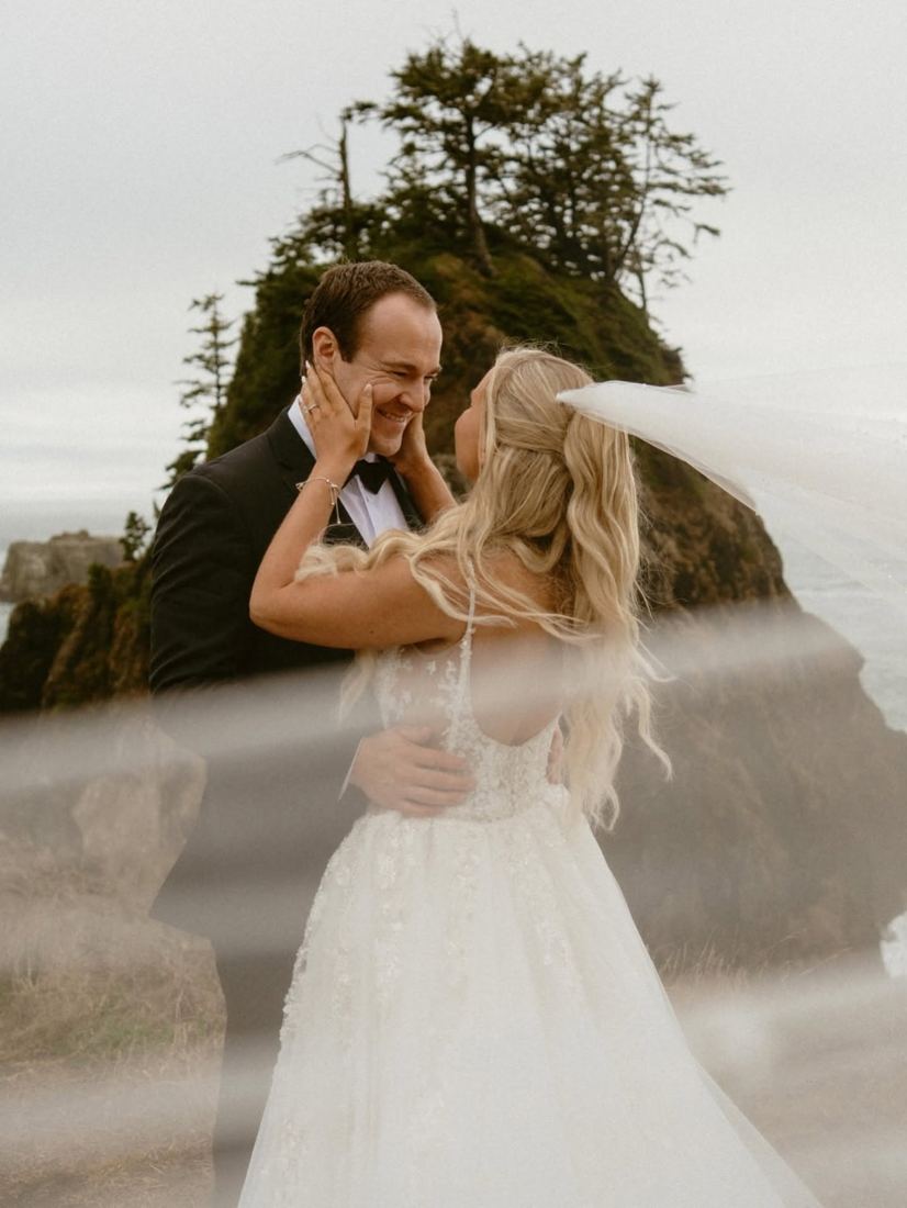 Bride with half-up blonde waves and a flowing veil at a coastal wedding